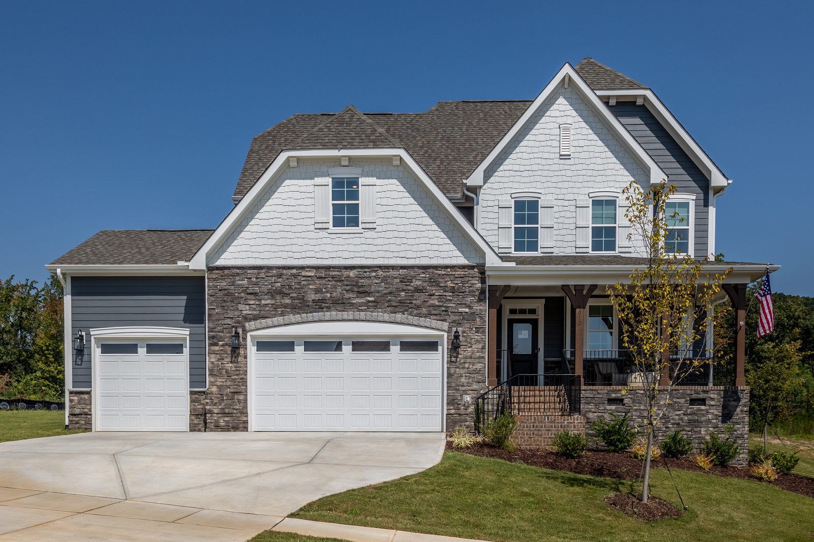 The Clark floorplan exterior, a two-story home with stone and shake accents